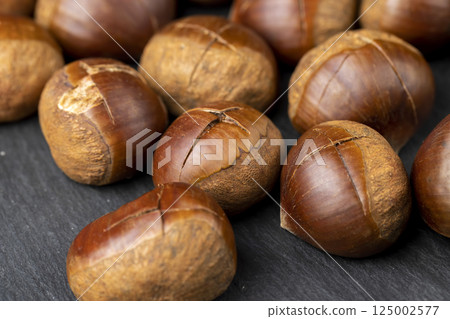 cutting the shells of edible chestnut nuts for baking cutting the shells of edible chestnut nuts for baking 125002577