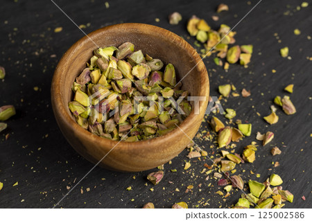 pistachios chopped and crushed into pieces of different sizes, a bunch of crunchy pistachios, closeup 125002586