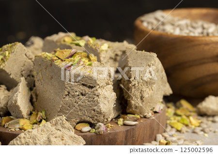 halva from sunflower seeds and crushed into one solid mass, a sweet delicious dessert made from seeds with pistachios, side view 125002596