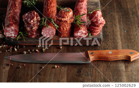 Sliced dry cured sausages with peppercorns, thyme, rosemary, and garlic. 125002629
