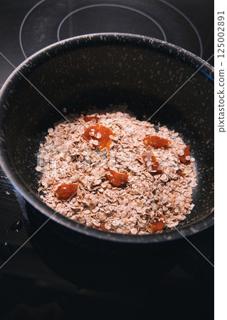 rolled oats, dark background, dried fruit 125002891