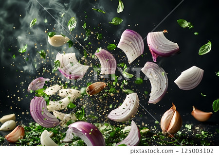 Dynamic arrangement of flying onion slices, herbs, and garlic in motion. 125003102