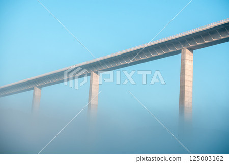 Autobahn bridge over dense fog, low angle view, in Braunsbach, Germany 125003162
