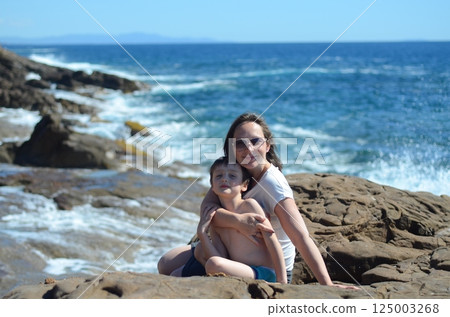 Mother and Child Enjoying a Day by the Ocean 125003268