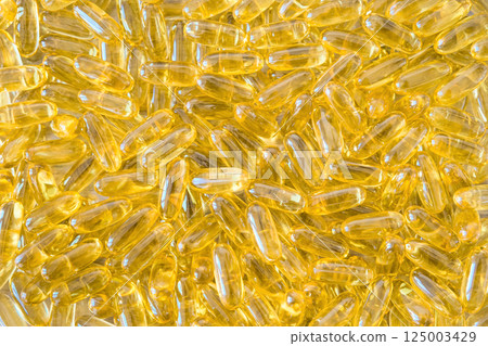 Fish oil capsules with omega 3 and vitamin D background. Health care concept 125003429