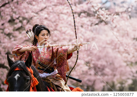 A woman shooting a bow in Yabusame 125003877
