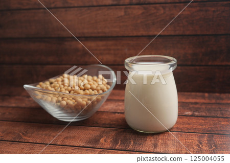 Soybeans and fresh soy milk displayed on wooden surface 125004055