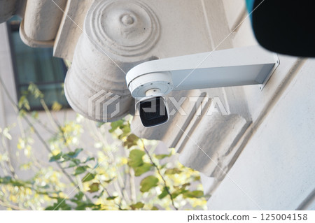 Security camera installed on a building exterior at daytime Security camera installed on a building exterior at daytime 125004158