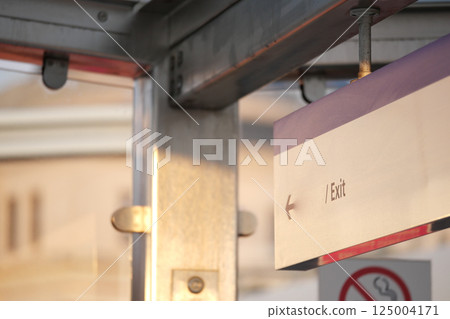 Exit sign in urban transit station during late afternoon light 125004171