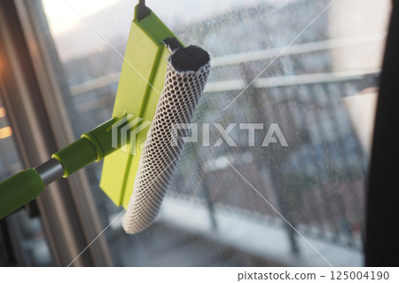 Window cleaning tool in action on a modern balcony 125004190