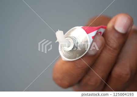 Hand holding a tube of ointment ready for application Hand holding a tube of ointment ready for application 125004193