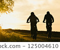 Two mointainbikers driving into the Sunset. 125004610