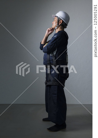 Elderly man wearing a helmet 125005291