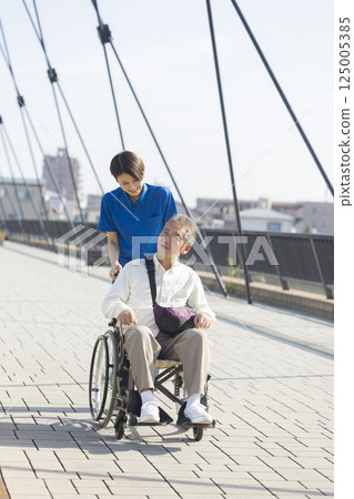 Senior men riding a wheelchair Senior men riding a wheelchair 125005385