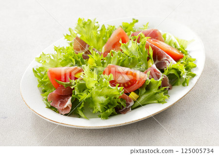 Tomato, prosciutto and leaf lettuce salad Tomato, prosciutto and leaf lettuce salad 125005734
