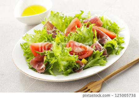 Tomato, prosciutto and leaf lettuce salad 125005738