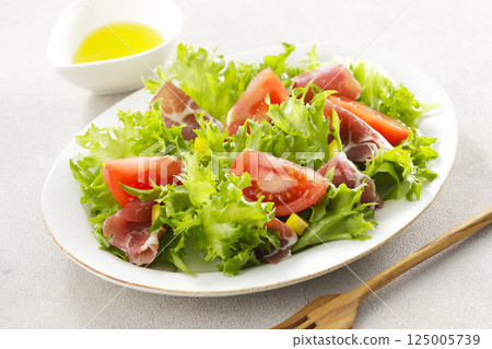 Tomato, prosciutto and leaf lettuce salad 125005739