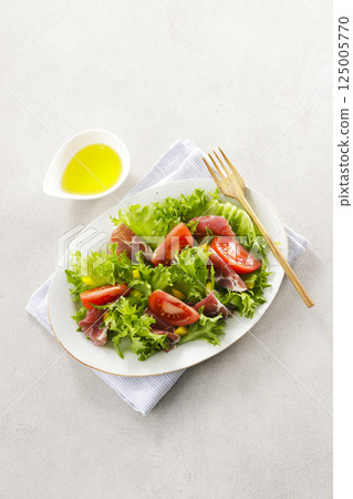 Tomato, prosciutto and leaf lettuce salad Tomato, prosciutto and leaf lettuce salad 125005770