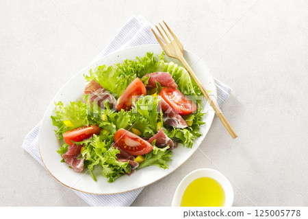 Tomato, prosciutto and leaf lettuce salad Tomato, prosciutto and leaf lettuce salad 125005778