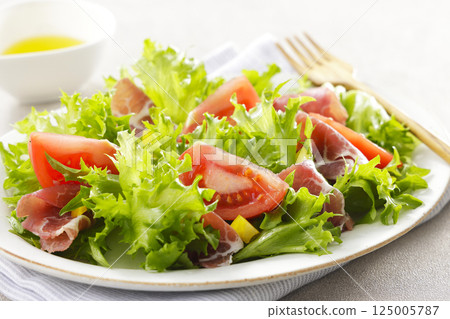 Tomato, prosciutto and leaf lettuce salad 125005787