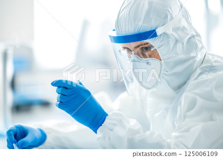 生物技術科學家在高度安全的無塵室中分析液體樣本 125006109