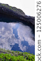 The sky reflected on the rocks of a cliff in a cove 125006276