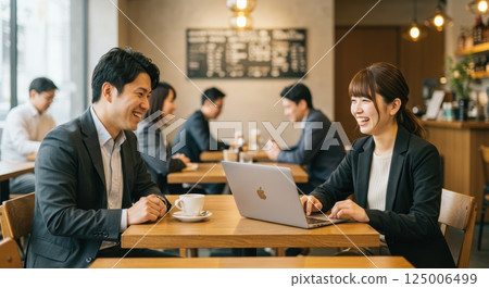 一名男子和一名女子在咖啡館使用電腦 125006499