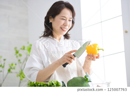 Middle woman cooking in the kitchen 125007763