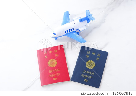 Image of a Japanese passport (red for 10 years and navy blue for 5 years) and an airplane planning a long holiday overseas trip Image of a Japanese passport (red for 10 years and navy blue for 5 years) and an airplane planning a long holiday overseas trip 125007913