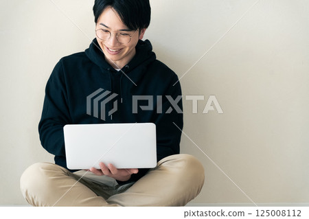 Man using a computer by the wall 125008112
