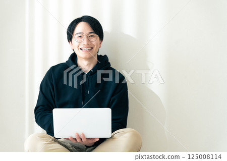 Man using a computer by the wall 125008114