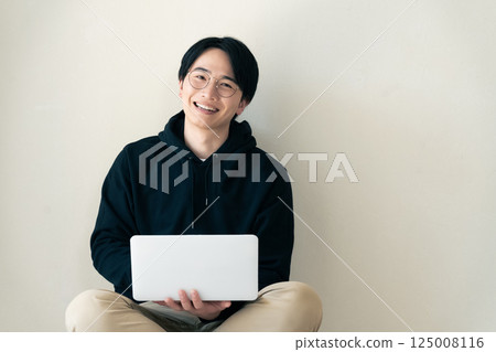 Man using a computer by the wall 125008116