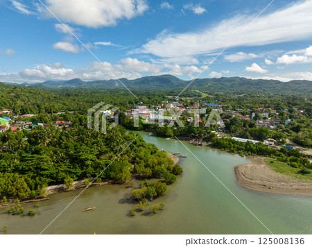 Tropical Island with houses and river. Looc, Poblacion. Blue sky and clouds. Tablas Island. Romblon, Philippines. Tropical Island with houses and river. Looc, Poblacion. Blue sky and clouds. Tablas Island. Romblon, Philippines. 125008136