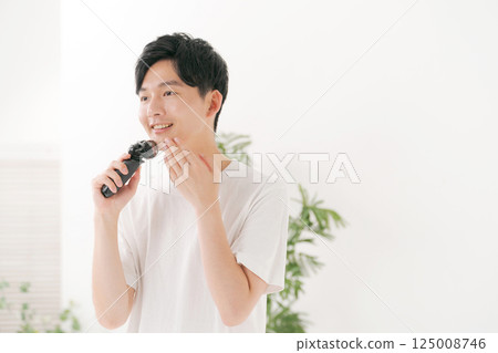 A young man shaving his beard A young man shaving his beard 125008746