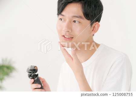 A young man shaving his beard A young man shaving his beard 125008755