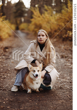 Woman with Corgi in Autumn Park Woman with Corgi in Autumn Park 125010221