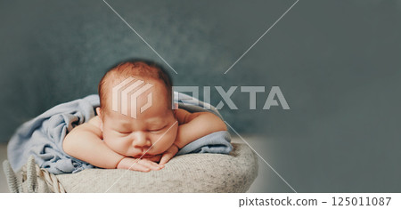 A newborn baby is wrapped in diapers with a wool cap in a basket. Swaddling, maternity hospital, family, ivf, life planning, parenting. A mother's love for her child. Baby food. High quality photo A newborn baby is wrapped in diapers with a wool cap in a basket. Swaddling, maternity hospital, family, ivf, life planning, parenting. A mother's love for her child. Baby food. High quality photo 125011087