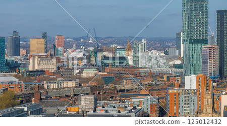 Aerial view of Manchester, UK, showcasing skyscrapers like Beetham Tower, the Town Hall clock tower, red brick buildings, and distant hills. Aerial view of Manchester, UK, showcasing skyscrapers like Beetham Tower, the Town Hall clock tower, red brick buildings, and distant hills. 125012432