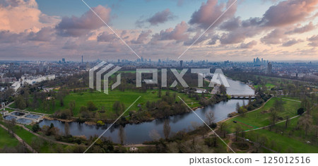 Aerial perspective of Hyde Park's green spaces and the Serpentine lake, with London's skyline, including The Shard and BT Tower, in the background. Aerial perspective of Hyde Park's green spaces and the Serpentine lake, with London's skyline, including The Shard and BT Tower, in the background. 125012516