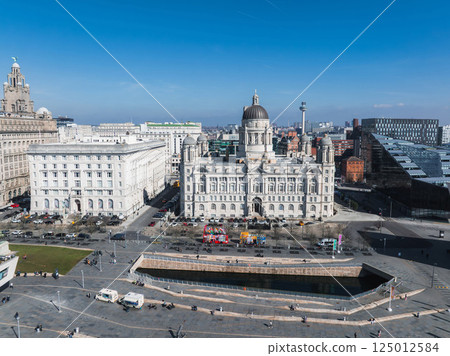 Aerial view of Liverpool showcasing the Port of Liverpool Building, Royal Liver Building, public square, pedestrians, vehicles, and a clear blue sky. Aerial view of Liverpool showcasing the Port of Liverpool Building, Royal Liver Building, public square, pedestrians, vehicles, and a clear blue sky. 125012584