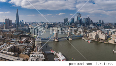 Aerial view of Tower Bridge over the River Thames, The Shard, and modern City of London buildings with boats and urban architecture in the scene. Aerial view of Tower Bridge over the River Thames, The Shard, and modern City of London buildings with boats and urban architecture in the scene. 125012599