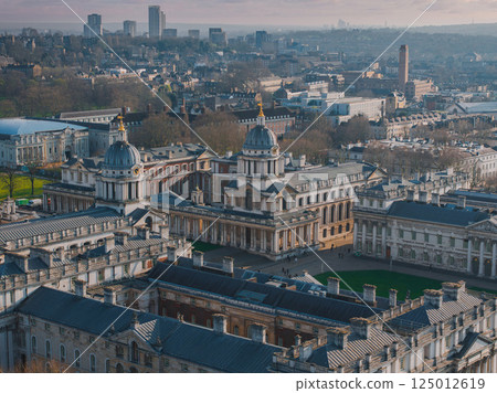 Aerial view of the Old Royal Naval College in Greenwich, London, featuring domed buildings, green spaces, and modern high rises in the background. 125012619