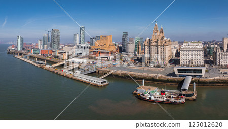 Aerial view of Liverpool showcasing the Royal Liver Building, Port of Liverpool Building, modern skyscrapers, River Mersey, and a docked ferry. 125012620
