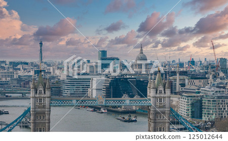 Aerial view of London's Tower Bridge over the River Thames, with St. Paul's Cathedral, the BT Tower, and urban development in the background. Aerial view of London's Tower Bridge over the River Thames, with St. Paul's Cathedral, the BT Tower, and urban development in the background. 125012644
