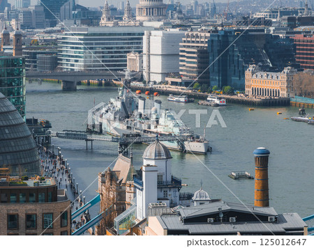 A vibrant aerial view of London with the River Thames, HMS Belfast, St. Paul's Cathedral, modern glass buildings, and historic architecture visible. 125012647