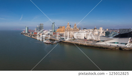Aerial view of Liverpool's waterfront with the Royal Liver Building, Cunard Building, Port of Liverpool Building, and the Museum of Liverpool by the Mersey River. 125012825