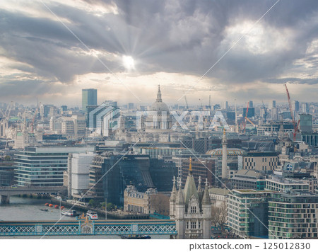 Aerial view of London with St. Paul's Cathedral at the center, Tower Bridge in the foreground, the Thames River, and a mix of architecture and construction. Aerial view of London with St. Paul's Cathedral at the center, Tower Bridge in the foreground, the Thames River, and a mix of architecture and construction. 125012830