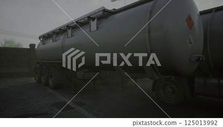Large gray tanker truck parked in low visibility conditions Large gray tanker truck parked in low visibility conditions 125013992