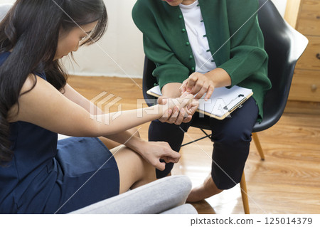 Asian psychologist doctor having session with young depressed woman in clinic. Psychology and mental therapy concept. 125014379