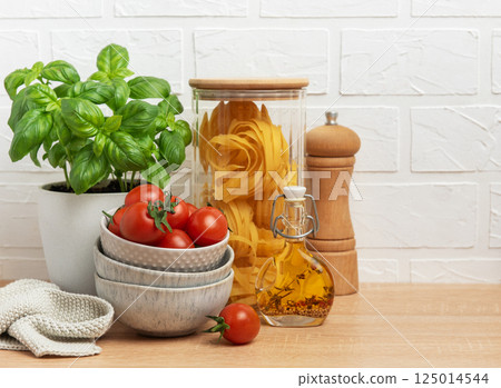 Cherry tomatoes, basil, pasta and olive oil creating an italian culinary scene 125014544